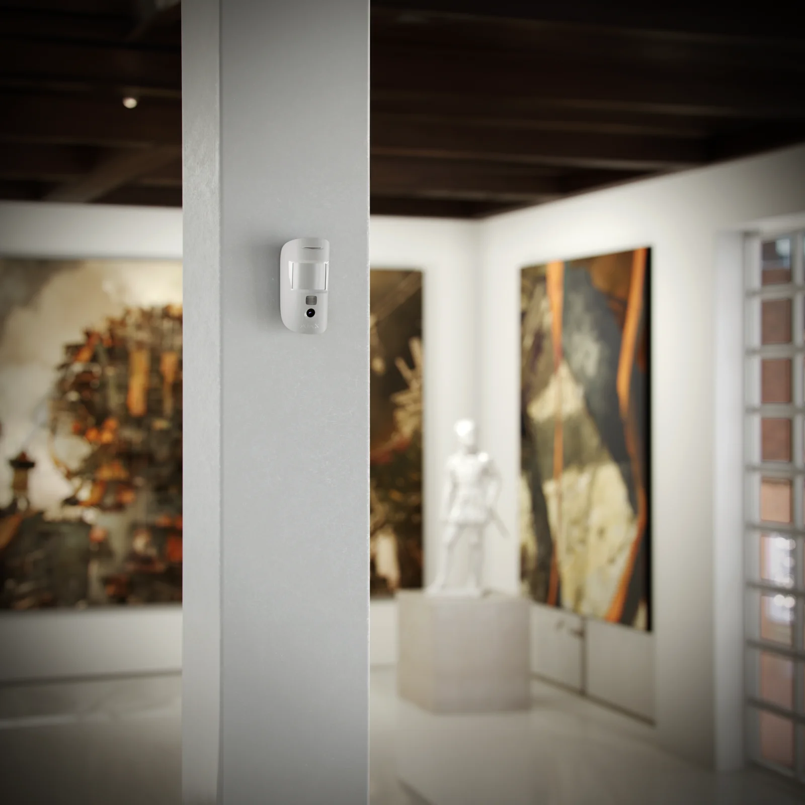 MotionCam Bewegungsmelder mit Kamera an einer Wand in einer Galerie montiert